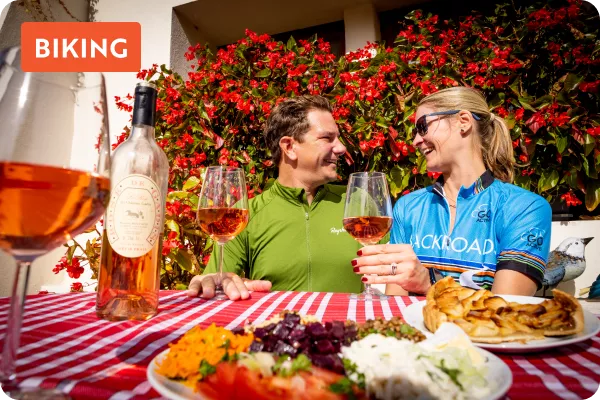 Man and woman smiling while holding glasses of wine