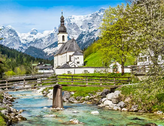 bridge over a river with church in the back
