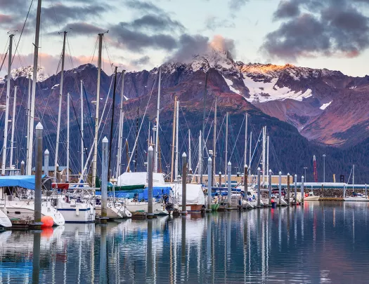 Shot of boat line at pier during sunset, mountain in distance.
