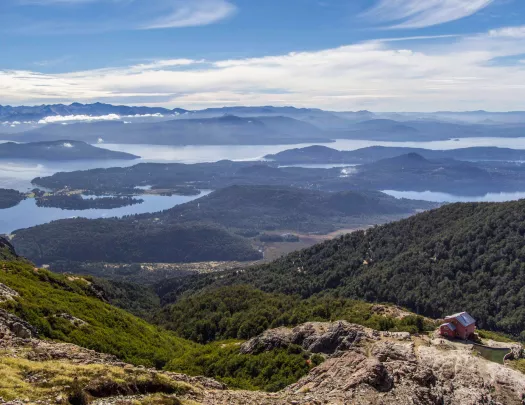 House on top of a mountain, with a valley of trees in the distance