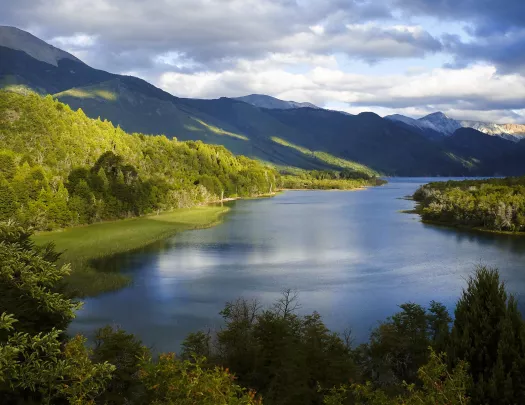 Large, open lake surrounded by tall trees and large hills