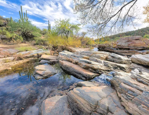 Small pond surrounded by large rocks in a desert valley