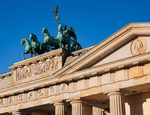 Rustic, stone building with green statues of horses on top