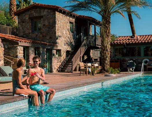 Guests relaxing poolside at desert resort.