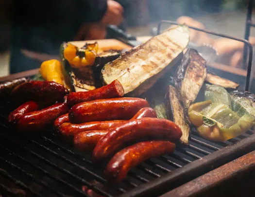 Close-up of searing sausages and veggies.
