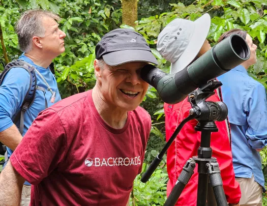 Man looking into a small telescope