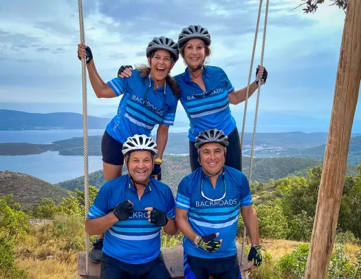 Four guests on large wood and rope swing.