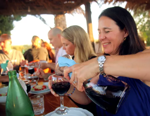 Woman smiling while pouring wine into a glass
