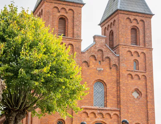 Red brick, castle like buildings with bikers in front