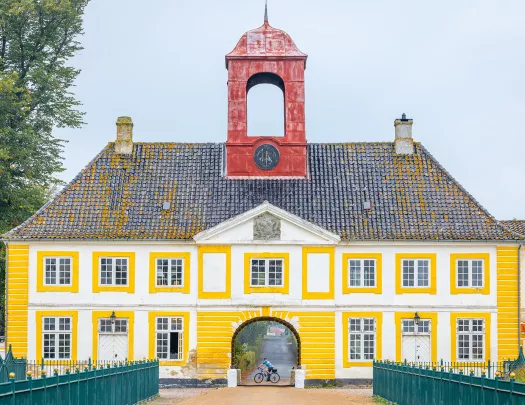 Yellow building with a red clocktower attached to the roof