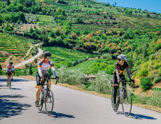 Three bikers riding on a road along the Douro River.