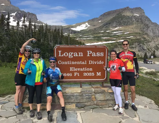 Backroads guest posing in front of sign with mountains in backgroud