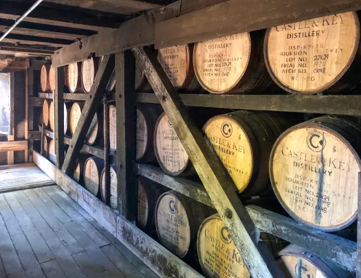 Distillery with large barrels inside large, wooden shelves