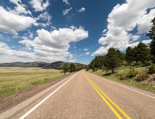 Long road in the middle of a large grass valley