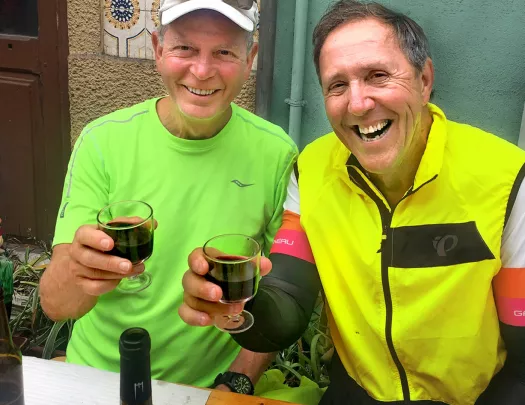 Two bikers saying cheers with glasses of red wine.