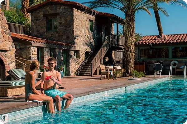 Two guests relaxing by a hotel pool