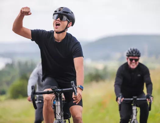 Man riding a bike, yelling with his fist in the air