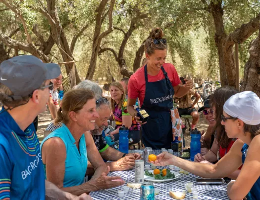Guests at BR lunch underneath shady trees.