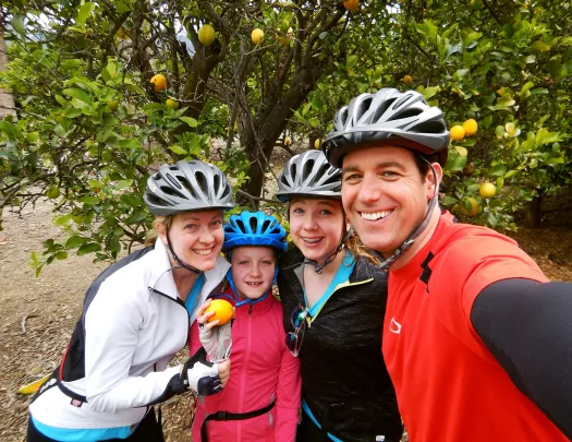 Four guests taking a selfie, orange tree behind them.
