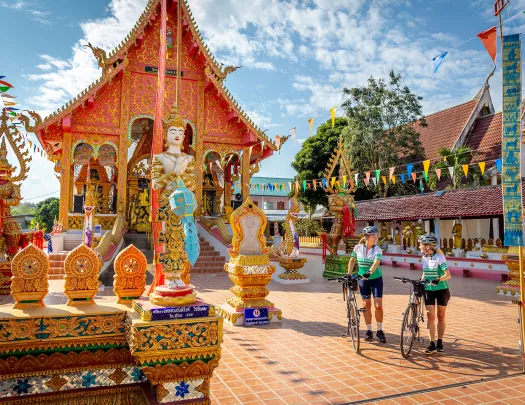 Two woman with bikes walking through a decorated town square