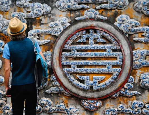 Guest in front of large painted longevity symbol.