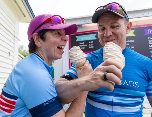 Man and woman interlocking arms and eating soft-serve ice cream