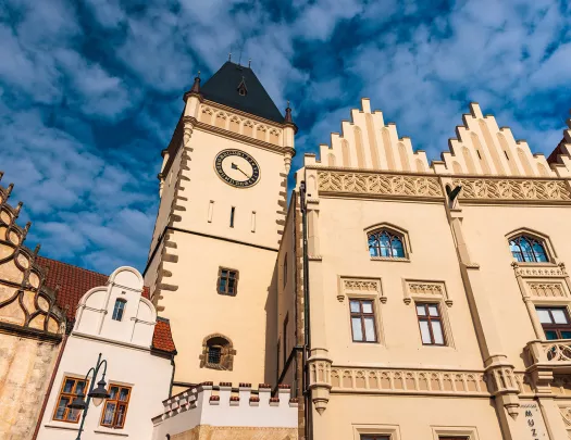 Concrete brown clocktower under a blue sky