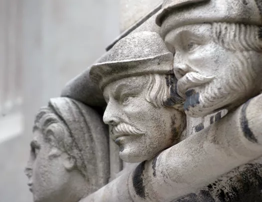 Statue of three men with black specks