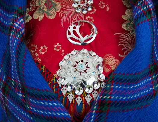 Front shot of colorful dress, medallions, blanket.