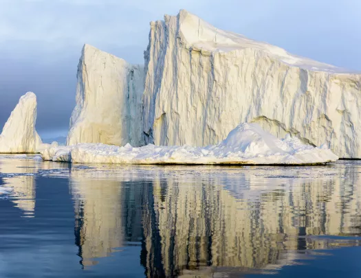 A large iceberg floating in blue water