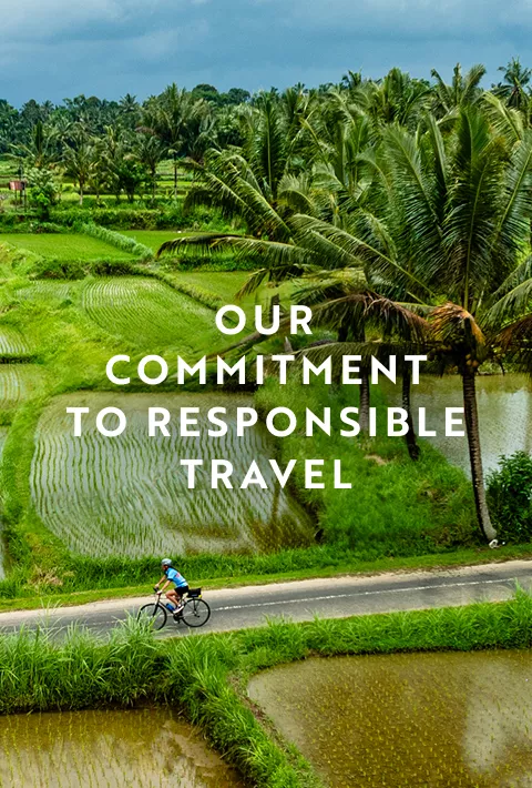 Cyclist riding through fields, overlay text: Our commitment to responsible travel
