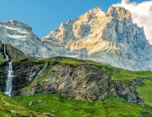 Grassy mountains in front of taller, foggy mountains