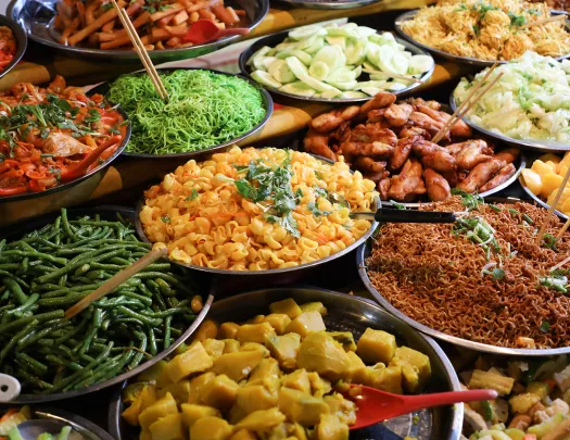 Large plates of noodles and cooked vegetables