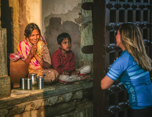 Woman bowing in front of another woman and her son