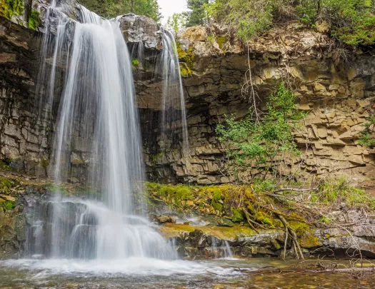 Shot of waterfall flowing into small lake.