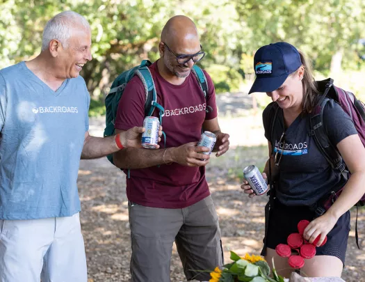 Three guests around lunch table, beers in hand.