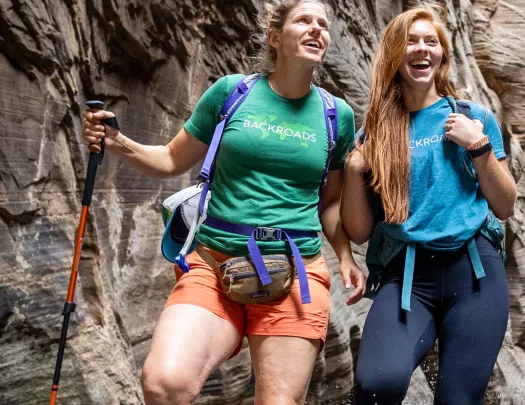 Two women hiking with large canyons behind them
