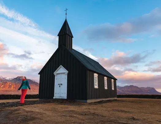 Hiker standing in front of church in Iceland.