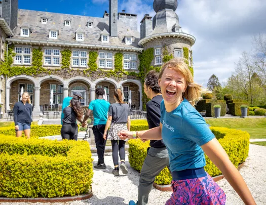 Guests walking towards stone building, one is smiling at camera.