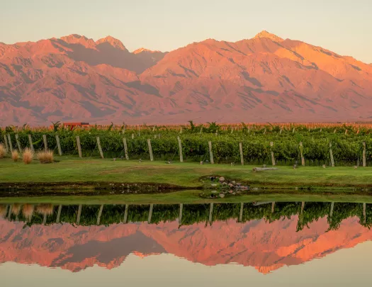 red mountain range reflected on water below it