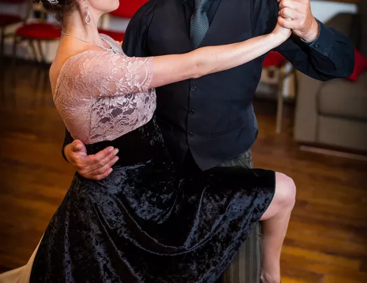 Two folks at dance class, dressed in black dancing clothes.