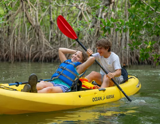 Two children kayaking in a river