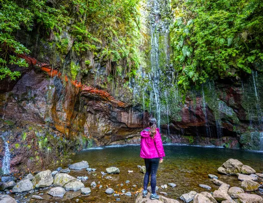 Woman standing on a rock looking at a lake 
