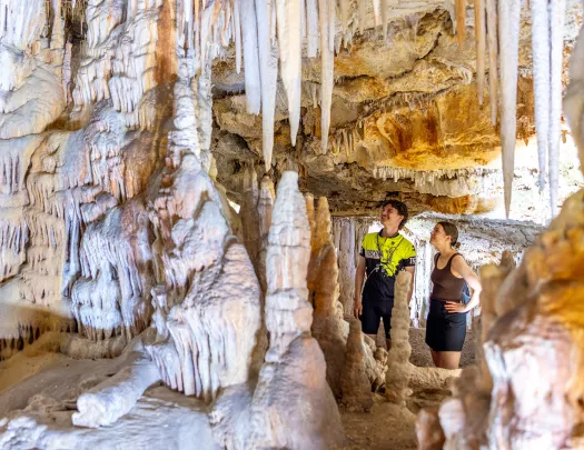 Man and woman inside of a white cave, looking up along the walls