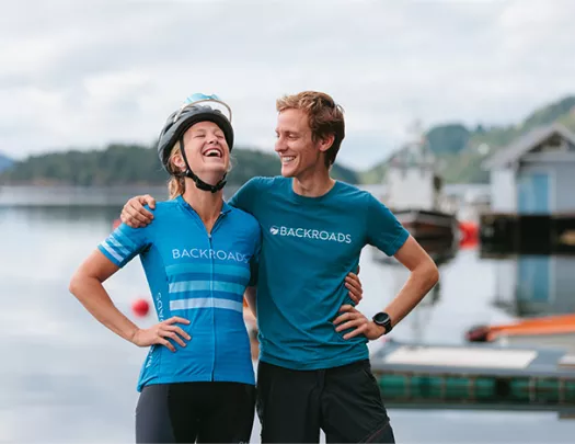 Two people laughing by body of water in Norway 
