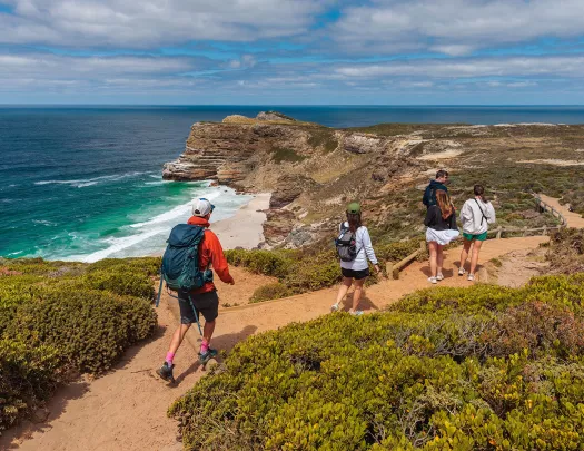 People hike down a beachfront road