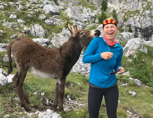 Guest on mountain trail, donkey beside her.