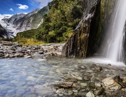 Waterfall flowing into a crystal clear river