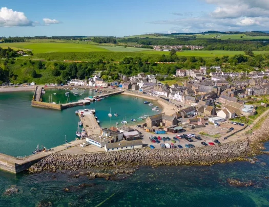 Brown buildings next to a small lake with a pier full of boats