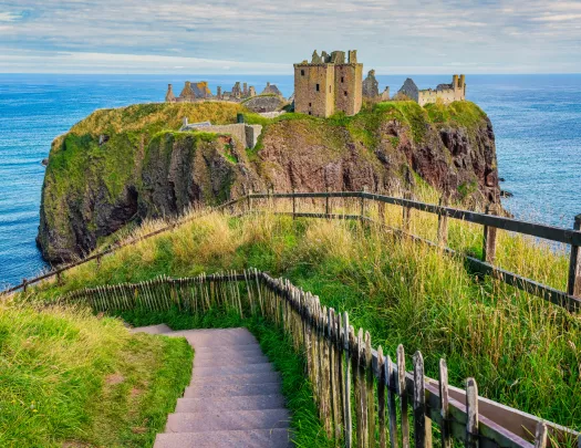 Rustic castle ruins on a cliff in the middle of an ocean